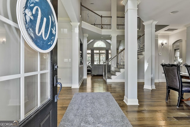 entryway with stairway, baseboards, ornate columns, and wood finished floors