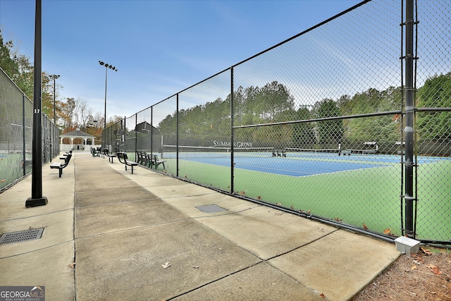 view of tennis court featuring fence