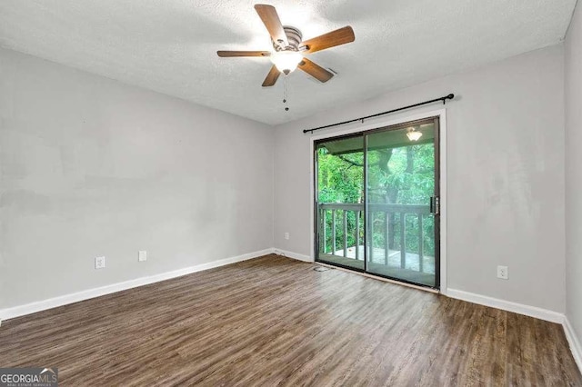 empty room featuring a ceiling fan, baseboards, wood finished floors, and a textured ceiling