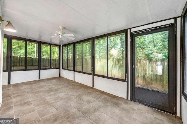 unfurnished sunroom with ceiling fan