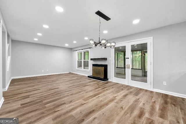 unfurnished living room with recessed lighting, baseboards, french doors, and wood finished floors