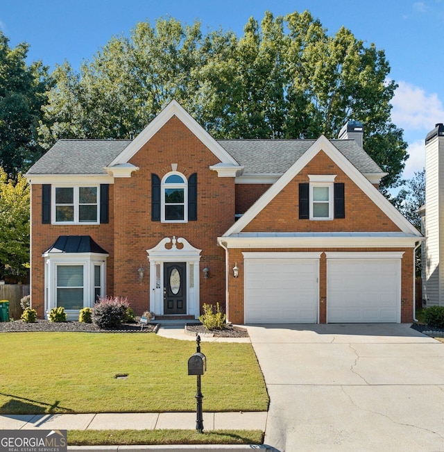 view of front of home with brick siding, concrete driveway, a front yard, an attached garage, and a chimney