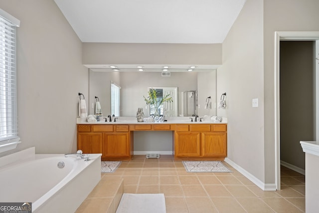 bathroom featuring a bath, double vanity, tile patterned floors, and baseboards