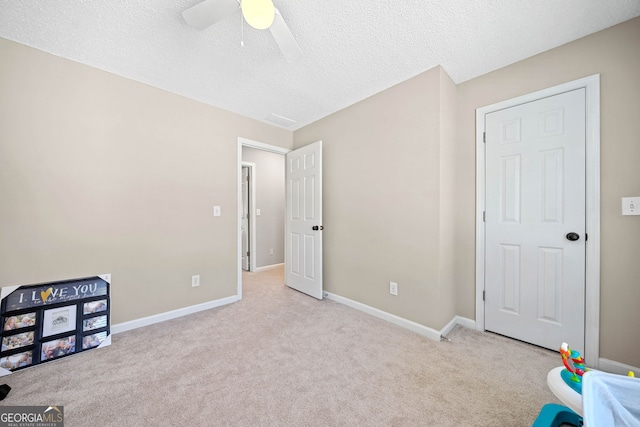 rec room featuring carpet floors, a ceiling fan, a textured ceiling, and baseboards