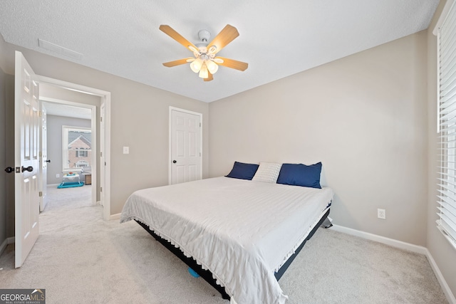 bedroom featuring light carpet, baseboards, and ceiling fan