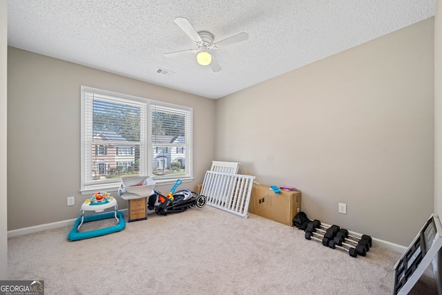 bedroom featuring carpet floors, a textured ceiling, a ceiling fan, and baseboards