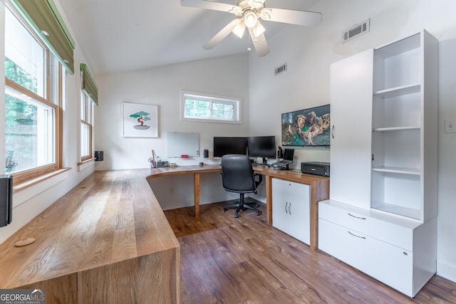 office space featuring healthy amount of natural light, wood finished floors, a ceiling fan, built in study area, and high vaulted ceiling