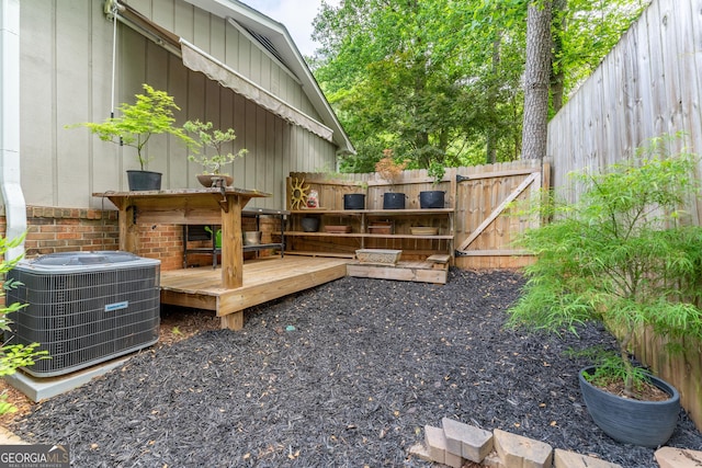 deck featuring central AC, a fenced backyard, and a gate
