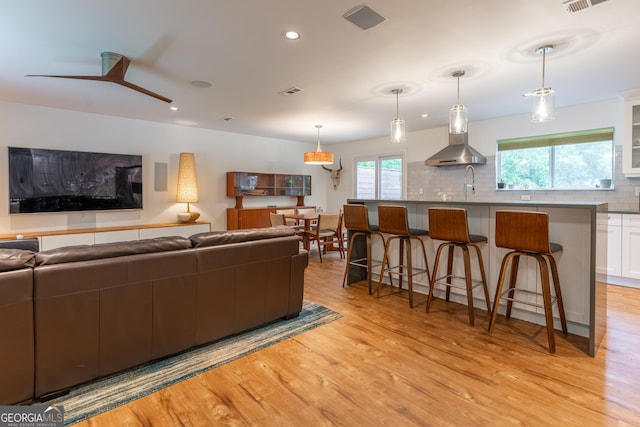 living area with light wood finished floors, recessed lighting, and ceiling fan