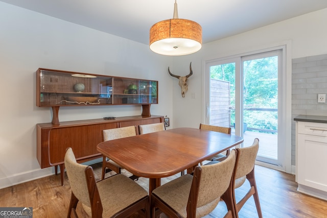 dining area featuring light wood-style flooring and baseboards