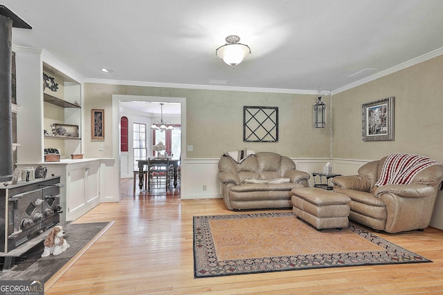 159 May Ln, Zebulon, GA 30295 - living room with crown molding, an inviting chandelier, a wainscoted wall, and light wood-style floors