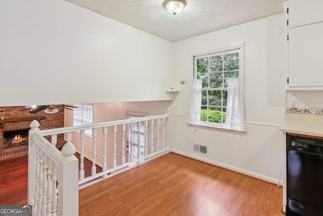 3240 Corktree Trl, Stonecrest, GA 30038 - interior space with ceiling fan, light wood-style floors, a brick fireplace, baseboards, and visible vents