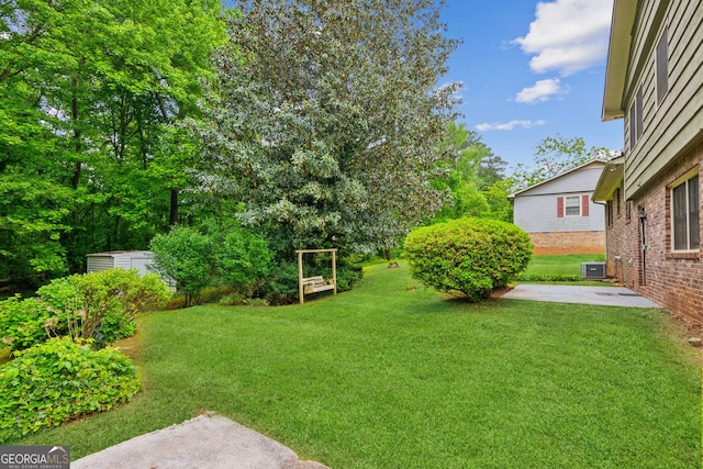 3240 Corktree Trl, Stonecrest, GA 30038 - view of yard featuring a patio area, central AC, an outbuilding, and a shed