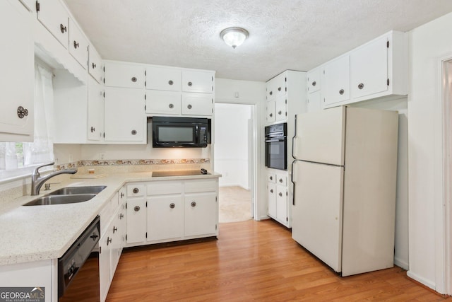 3240 Corktree Trl, Stonecrest, GA 30038 - kitchen featuring white cabinets, a sink, black appliances, and light wood-type flooring
