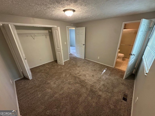 2036 Countydown Ln, Stone Mountain, GA 30088 - unfurnished bedroom with a closet, a textured ceiling, carpet flooring, baseboards, and ensuite bathroom
