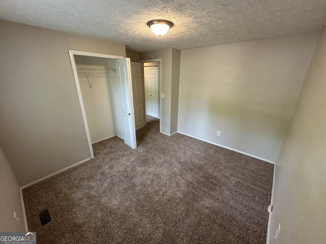 2036 Countydown Ln, Stone Mountain, GA 30088 - unfurnished bedroom featuring carpet floors, a closet, a textured ceiling, and baseboards