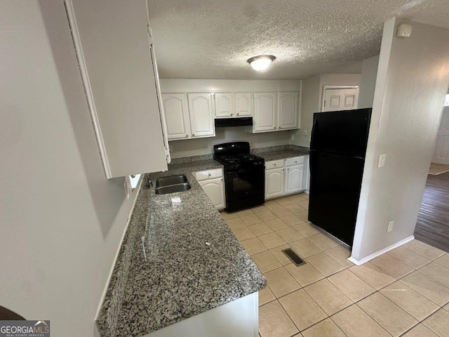 2036 Countydown Ln, Stone Mountain, GA 30088 - kitchen with black appliances, under cabinet range hood, a sink, white cabinetry, and light tile patterned floors