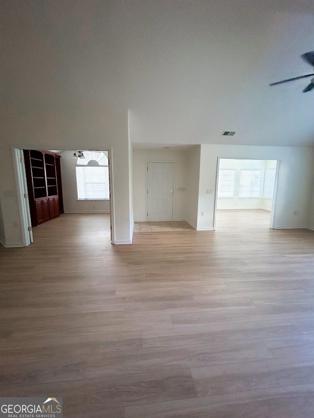 3077 Oakside Cir, Milton, GA 30004 - unfurnished living room featuring healthy amount of natural light, light wood-type flooring, and a ceiling fan