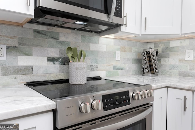 kitchen with light stone counters, white cabinetry, appliances with stainless steel finishes, and tasteful backsplash