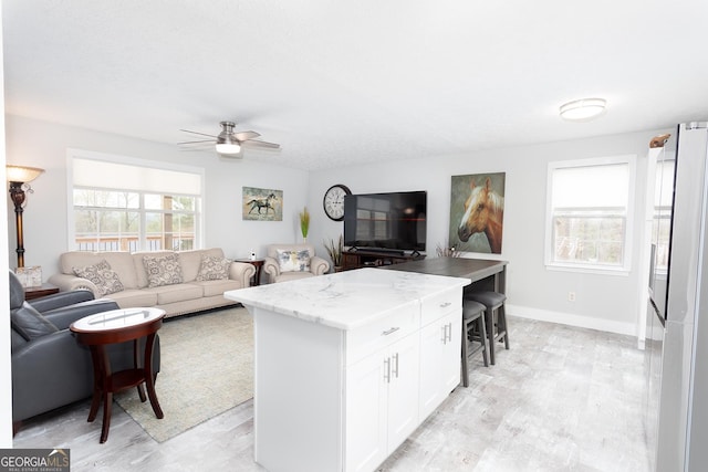 kitchen with light wood-style floors, open floor plan, and white cabinetry