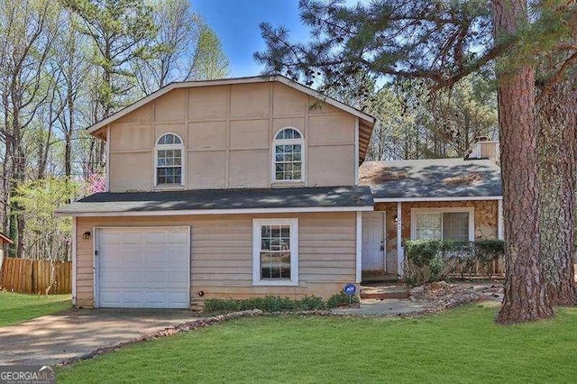 tri-level home with a garage, fence, driveway, and a front lawn