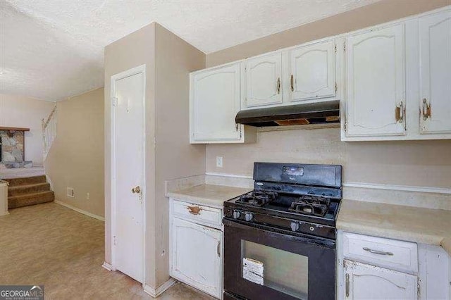 1045 Forest Path, Stone Mountain, GA 30088 - kitchen with black gas range, under cabinet range hood, light countertops, a textured ceiling, and white cabinets