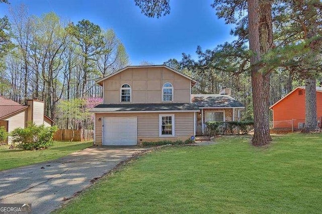 tri-level home featuring fence, an attached garage, driveway, and a front lawn