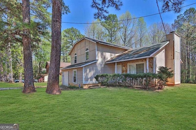 tri-level home featuring a garage, a chimney, and a front lawn