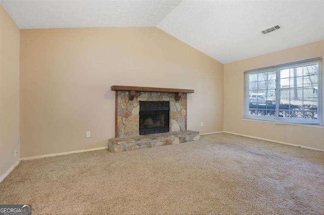 unfurnished living room with visible vents, a fireplace, vaulted ceiling, carpet floors, and baseboards