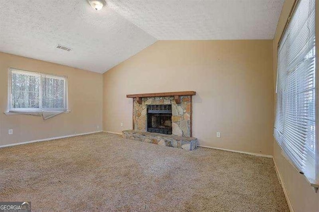 unfurnished living room with visible vents, carpet flooring, a textured ceiling, and lofted ceiling