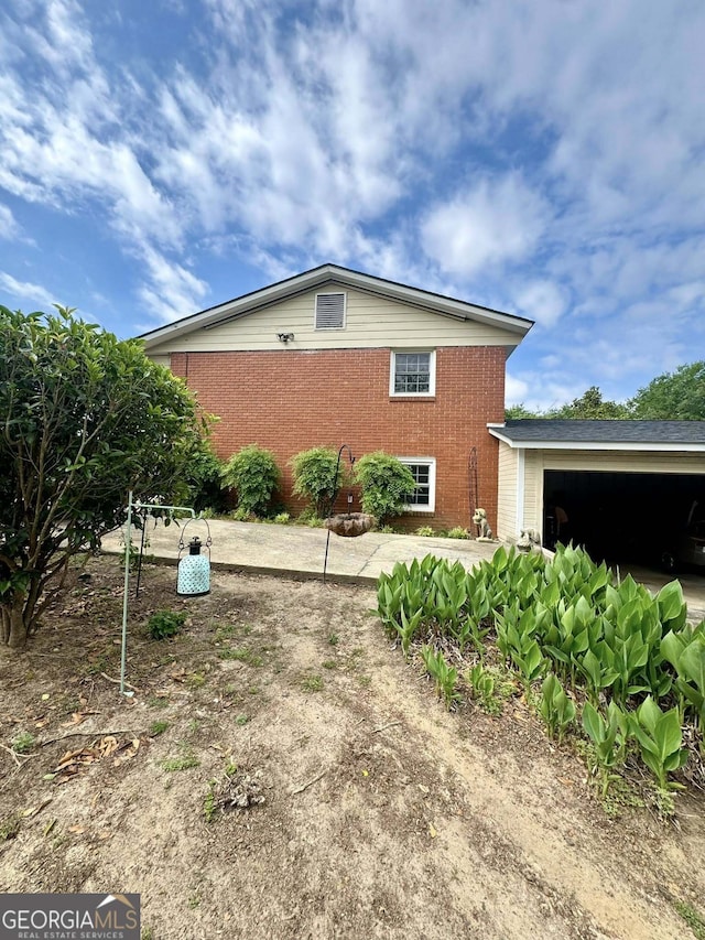 view of home's exterior with brick siding and an attached garage