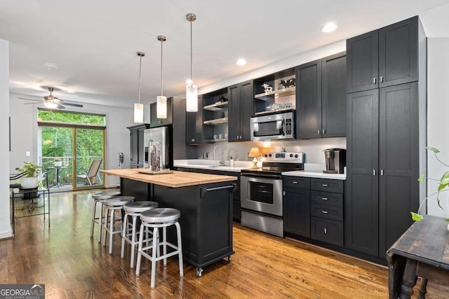 1346 Peter Haughton Way NW, Atlanta, GA 30318 - kitchen featuring stainless steel appliances, butcher block counters, open shelves, a kitchen bar, and a kitchen island