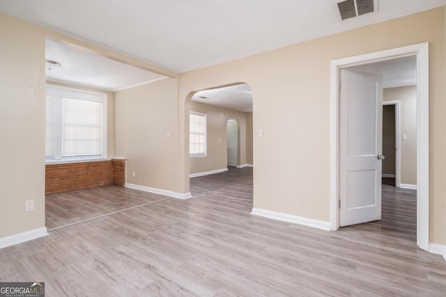 1774 Campbellton Rd, Atlanta, GA 30311 - empty room featuring visible vents, arched walkways, light wood-style flooring, and baseboards