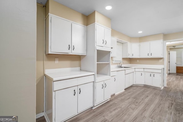1774 Campbellton Rd, Atlanta, GA 30311 - kitchen with light wood-type flooring, recessed lighting, light countertops, white cabinets, and a sink