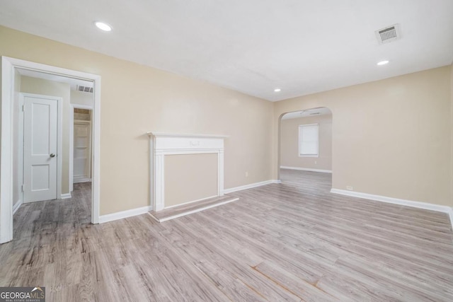 1774 Campbellton Rd, Atlanta, GA 30311 - unfurnished living room with visible vents, arched walkways, baseboards, and wood finished floors