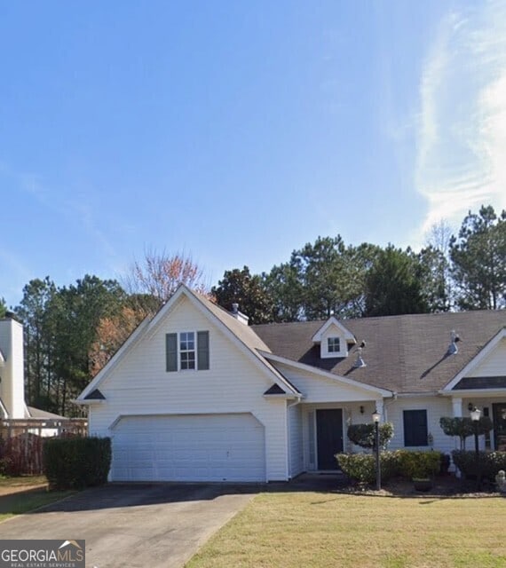 view of front of property with a garage, a front lawn, and concrete driveway