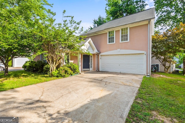 traditional-style house with a garage, driveway, a front lawn, and stucco siding