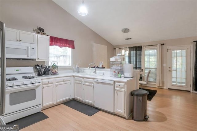 3130 Jorden Crest Ct, Lawrenceville, GA 30044 - kitchen with white appliances, a peninsula, lofted ceiling, and light wood-type flooring