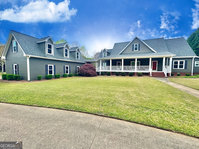 view of front facade with a porch, a front lawn, and roof with shingles