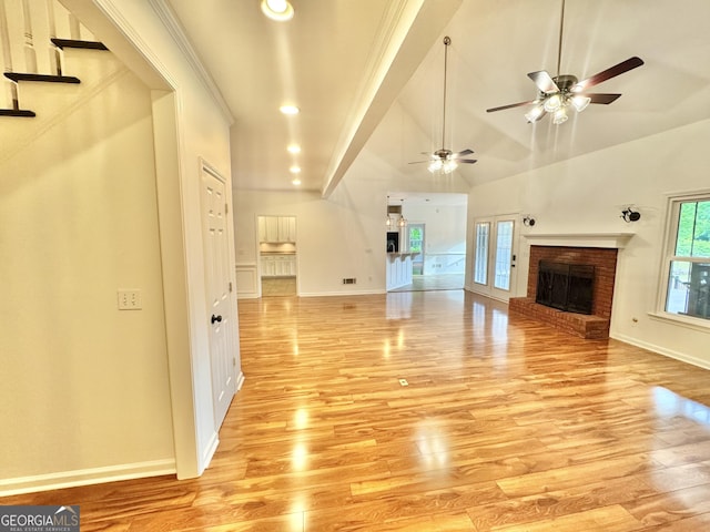 unfurnished living room with a brick fireplace, light wood finished floors, ceiling fan, and baseboards