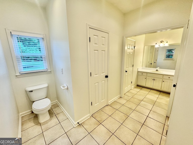 bathroom with vanity, baseboards, tile patterned floors, and toilet