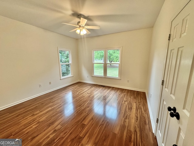 unfurnished room featuring dark wood-style flooring, baseboards, and a ceiling fan