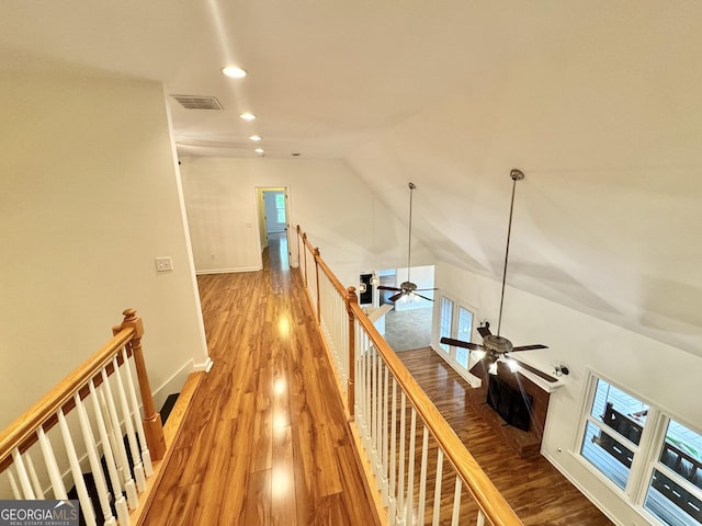 hallway with visible vents, recessed lighting, an upstairs landing, wood finished floors, and vaulted ceiling