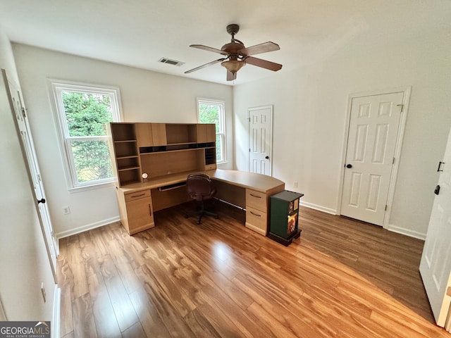 home office featuring baseboards, ceiling fan, visible vents, and wood finished floors