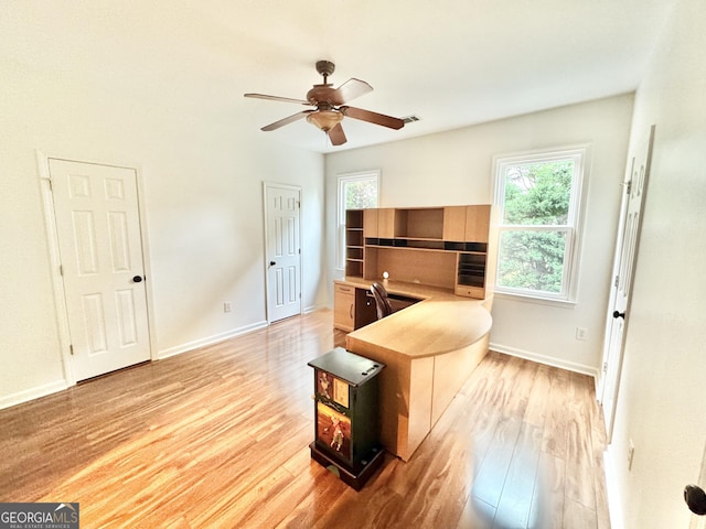 office space with baseboards, ceiling fan, and light wood-style flooring