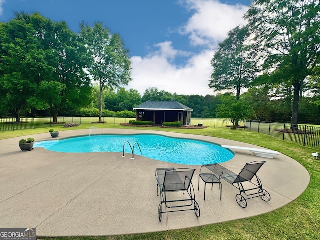 view of pool featuring an outdoor structure, fence, a fenced in pool, a patio area, and a lawn