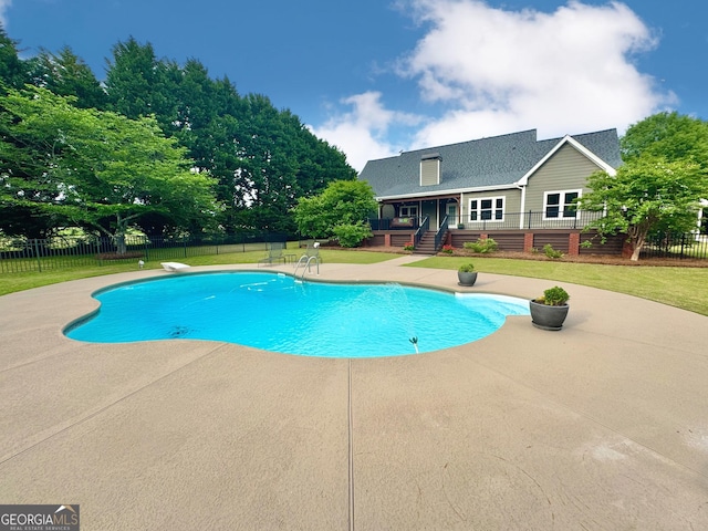 view of pool featuring a wooden deck, a fenced in pool, and a patio
