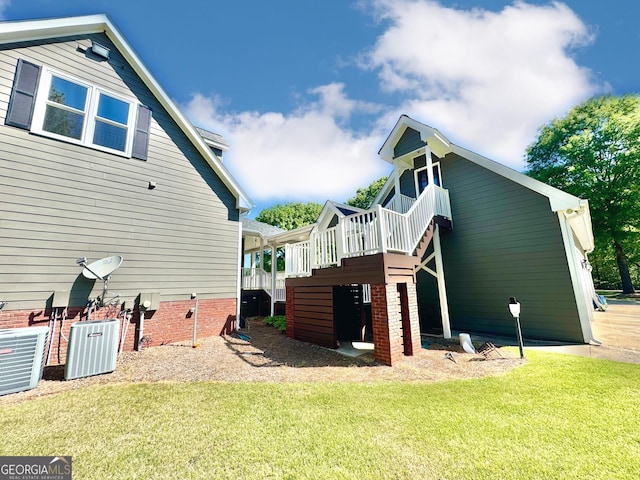 back of house with stairway, central air condition unit, a yard, and a deck