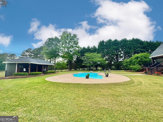 view of swimming pool featuring a lawn, fence, and a fenced in pool