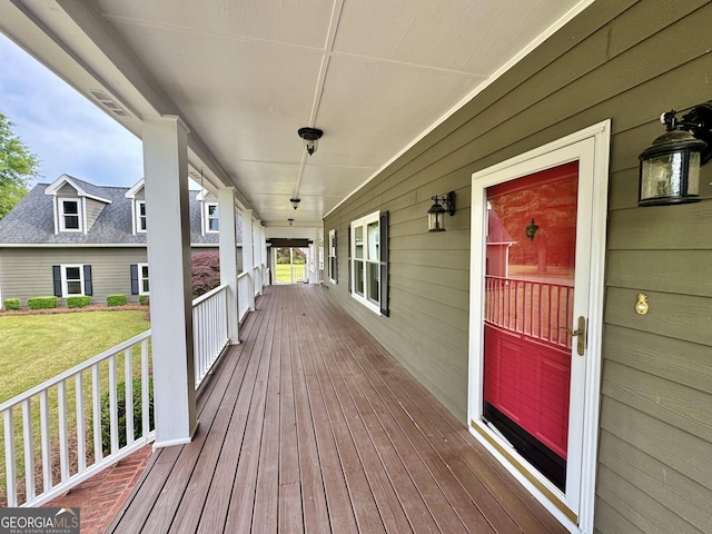 deck featuring a porch and a lawn